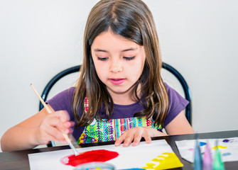 Portrait of cute girl concentrated while painting