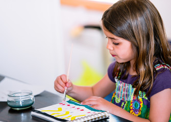 Portrait of cute girl concentrated while painting