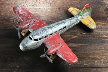 altes Blechflugzeug auf Holzhintergrund