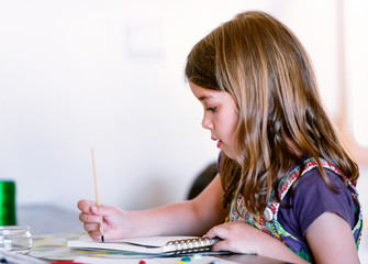 Portrait of pretty girl concentrated while painting