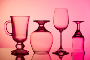 Several different glass of wine glasses on a red background.