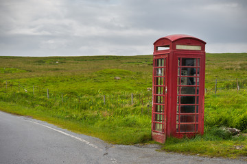 Red telephone booth in rural landscape, Skye, Scotland