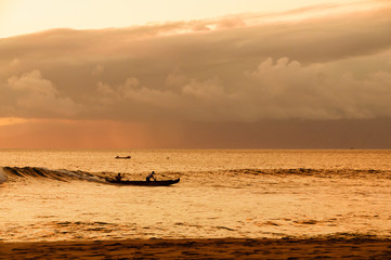 Obraz premium Two men paddling a Hawaiian outrigger canoe at sunset, Maui, Haw