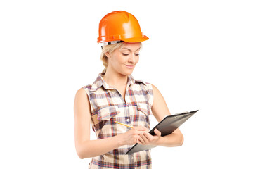 Female mechanic writing on a clipboard