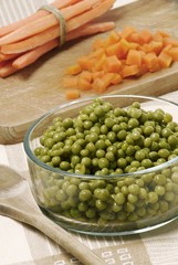 Peas in glass bowl and carrots, partly diced