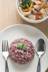 Rice mix purple rice berry rice with chicken soup on wood table.