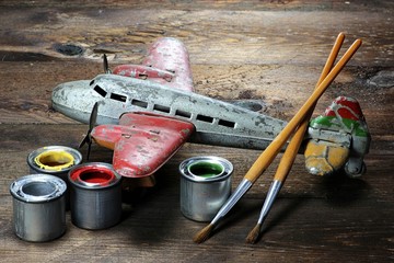 altes Blechflugzeug mit Farbtöpfen und Pinseln zur Restauration