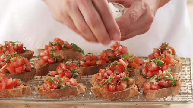 Bruschetta being sprinkled with salt