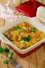 Pilaf with meat in a pot on a wooden table