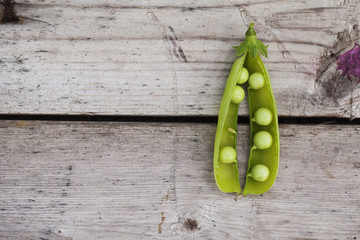 Green open pea on wooden plank table