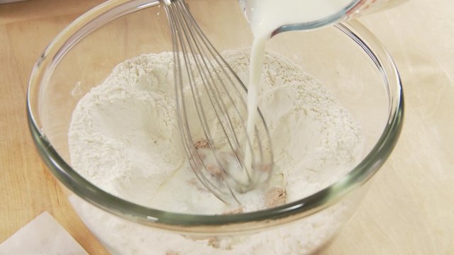 Lukewarm milk being added to milk, yeast and sugar