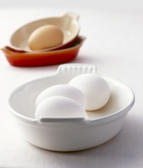Fototapeta na wymiar White and brown eggs in baking dishes