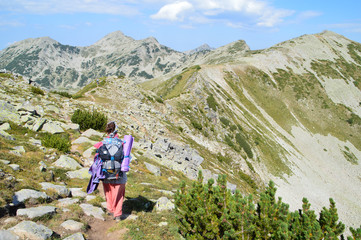 Naklejka na ściany i meble Young Woman Walking On A Trail High Mountain Ridge