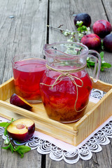 Stewed plums in a jar on a wooden background