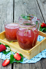Compote of strawberries in a jar on a wooden background