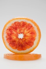 Slice of blood orange, standing on its edge