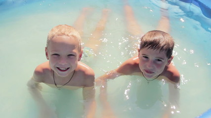 two boys close-up of sprinkles in the pool, 1080p