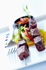 Beef kebabs on vegetables