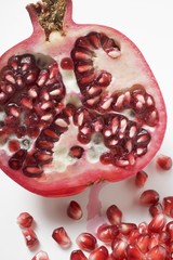 Half a pomegranate and several pomegranate seeds