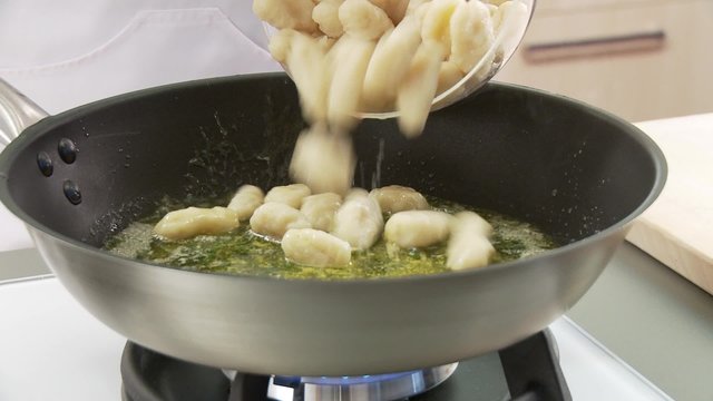 Gnocci being added to a pan of melted butter and sage
