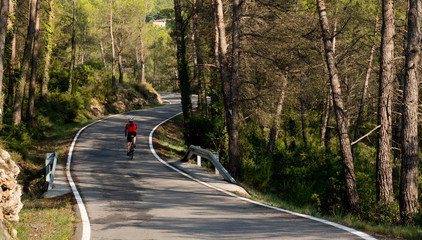 Fototapeta premium Cyclist in road with curves