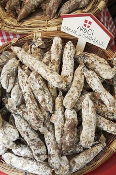 Wild boar sausages in a basket on a market stall (Italy)