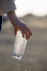 Hand holding a glass of mineral water