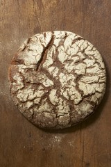 A loaf of rye bread on wooden background