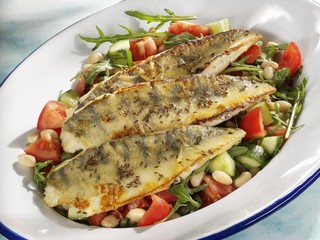 Fried zander fillets on a bed of vegetables