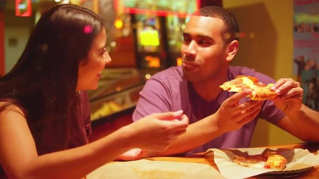A young couple eating at a downtown pizzeria