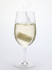 Cork falling into a glass of white wine