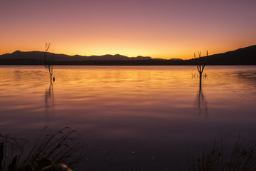 Fototapeta na wymiar Beautifully rich coloured sunset on a winters evening at Lake Moogerah in Queensland, Australia