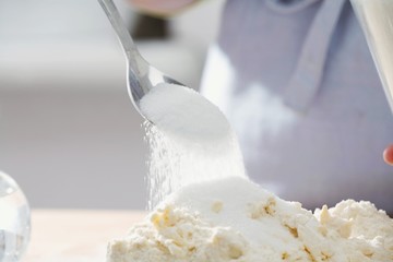Baking a cake: sprinkling sugar over mixed butter and flour