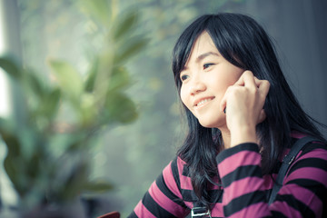 Beautiful asian young woman speaking by mobile phone