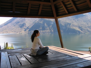 Junge Frau meditiert an See Variante