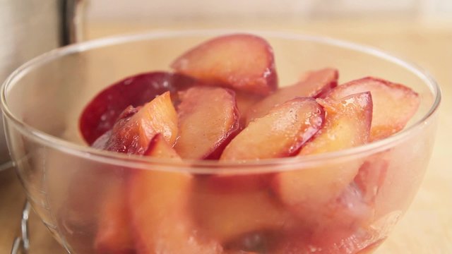 Stewed plums being put into a bowl