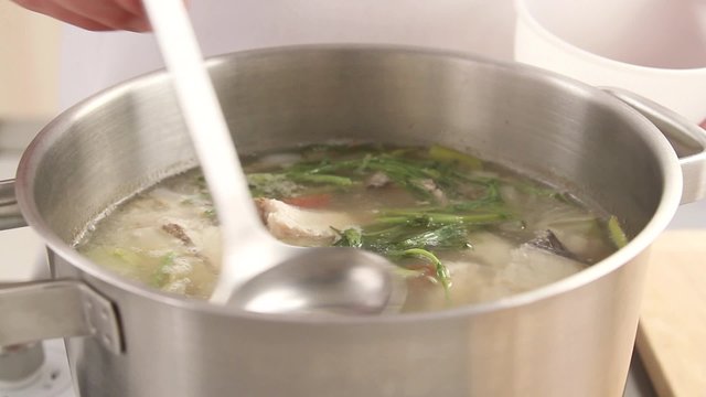 Foam being scooped off fish stock