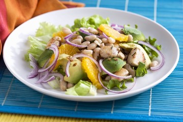 Lukewarm chicken salad with beans, avocado and oranges