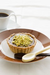 A chocolate tart topped with pistachios and halva