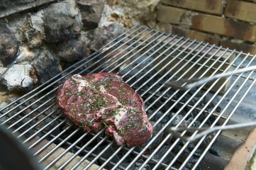 A beef steak with herbs on a barbecue