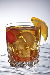 Classic Old Fashioned Cocktail in a Glass with Ice, Cherry and an Orange Wedge Garnish