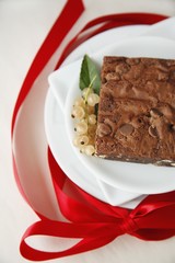 A Chocolate Chip Brownie with White Currants and a Red Ribbon