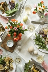 Easter Table with Full Dinner Plates, Flowers, Eggs and Wine; From Above