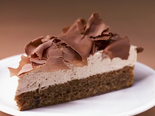 A slice of French walnut cake with chocolate curls