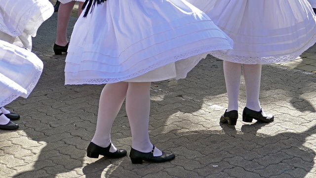 Serbian dancers in traditional costumes who perform the movements of a serbian dance (4K)