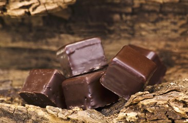 Dominosteine (chocolate covered sweets with marzipan and gingerbread) on a piece of wood