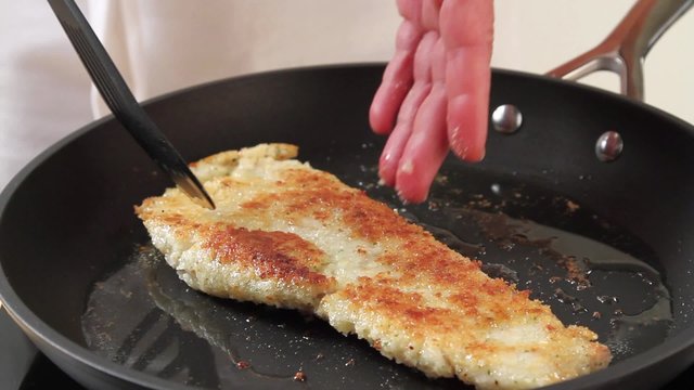 Breaded haddock being fried in a pan