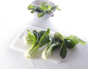 Wet pak choi on a chopping board