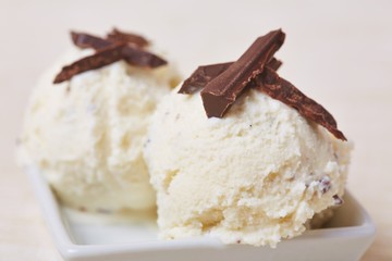Two scoops of home-made stracciatella ice cream topped with grated chocolate