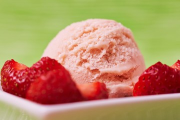 A scoop of strawberry ice cream with strawberry pieces